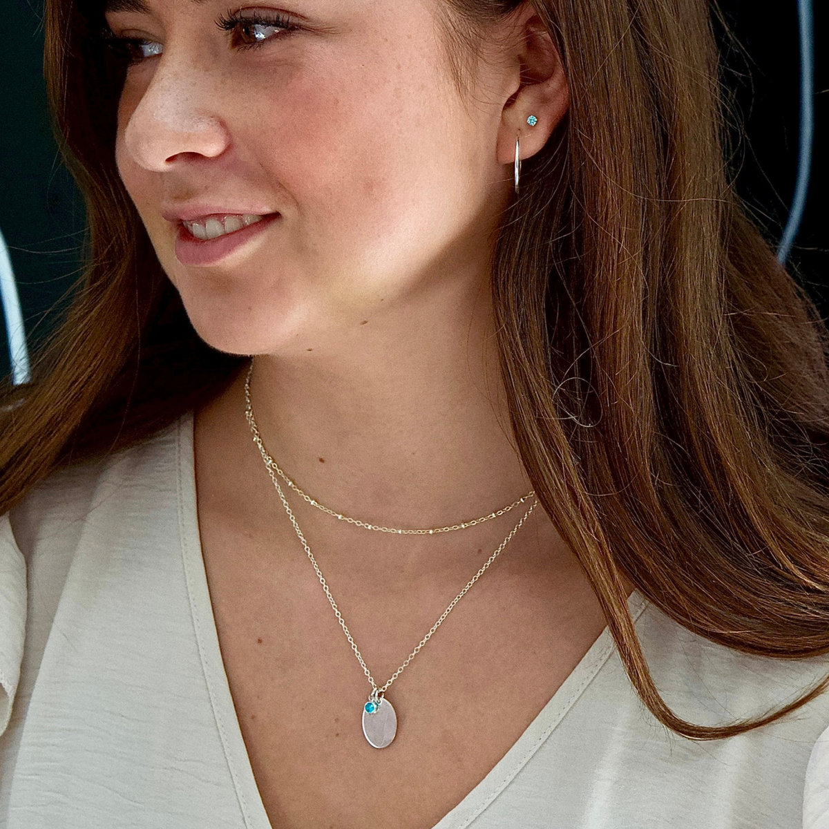 Silver Oval Pendant with Footprint Laser, 4mm Birthstone Pendant Attached - Further away on Woman&#39;s Neck.